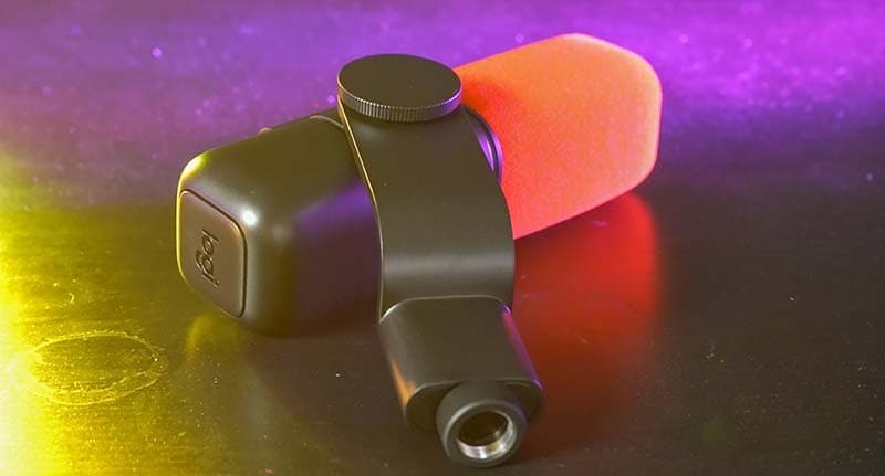 The Logitech Blue Sona placed flat on a table. The microphone is graphite colour, a capsule design with a red windshield.