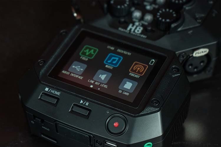 A close-up shot of the Zoom H8 screen, showing the three apps: Music, Podcast & Field Recording.